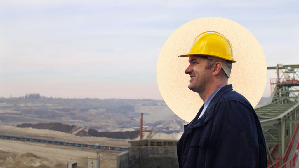 A smiling reclamation worker wearing a construction hat.