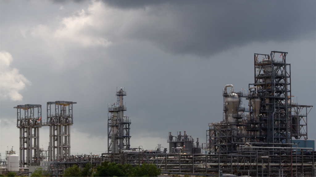 Dark clouds loom over a petrochemical facility.