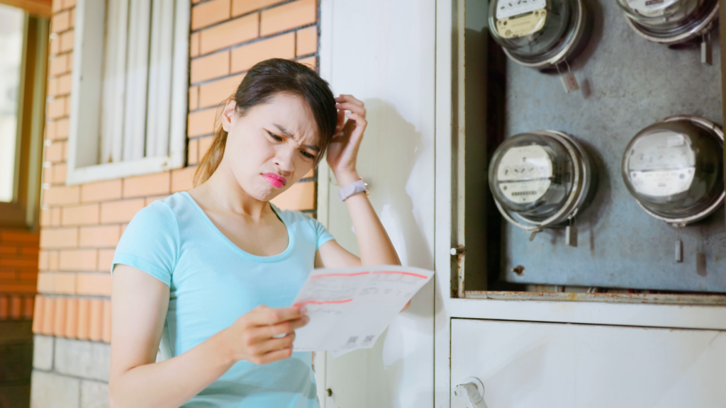 A woman scratches her head while reading an electricity bill.