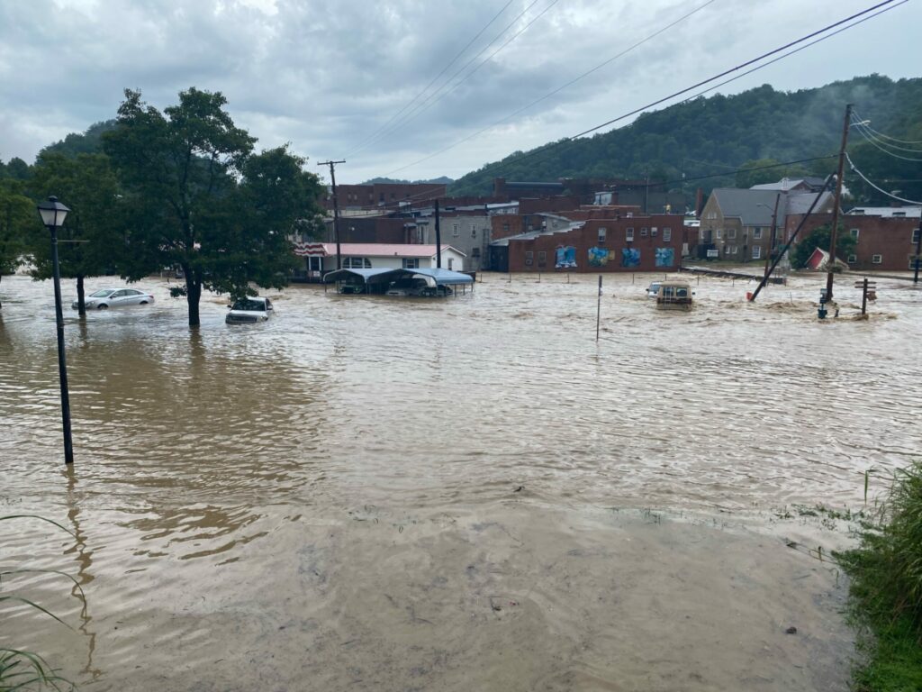 Floodwaters swamp vehicles, utility lines, and houses in Eastern Kentucky.