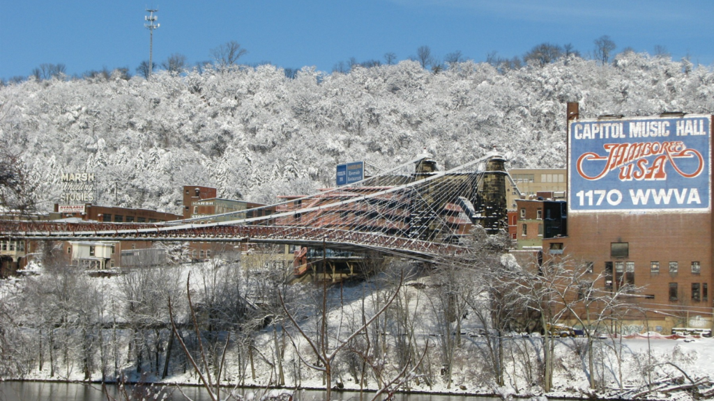 A snow-covered Wheeling Suspension Bridge stretches before the Capitol Theatere in Wheeling, West Virginia.