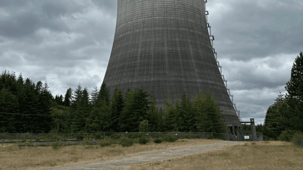 A dark, cloudy sky looms behind a cooling tower of the abandoned Satsop Nuclear Power Plant near Elma, Washington.